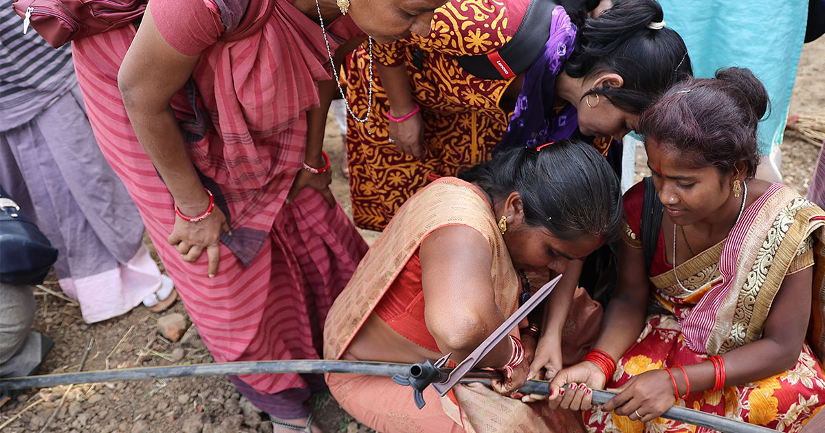 Image of several Indian woman struggling with water pipeline used as a banner for an article titled "SHL Medical Supports The “Water Drop Initiative” Introducing Spowdi Smart Farming To The Sewa Sisters"